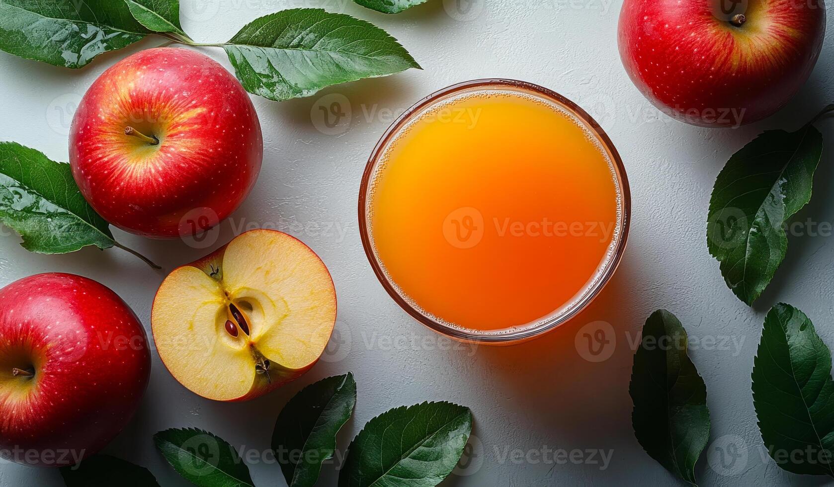A glass of juice is poured over a bowl of sliced apples photo