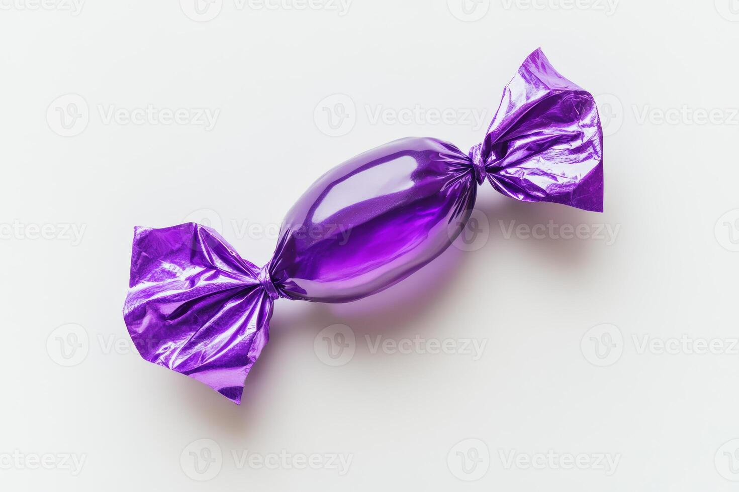 This candy is a vibrant, shiny purple delight, elegantly wrapped in foil, showcasing its irresistible sweet treat allure. Perfectly suited for colorful celebrations, parties, and delightful desserts photo