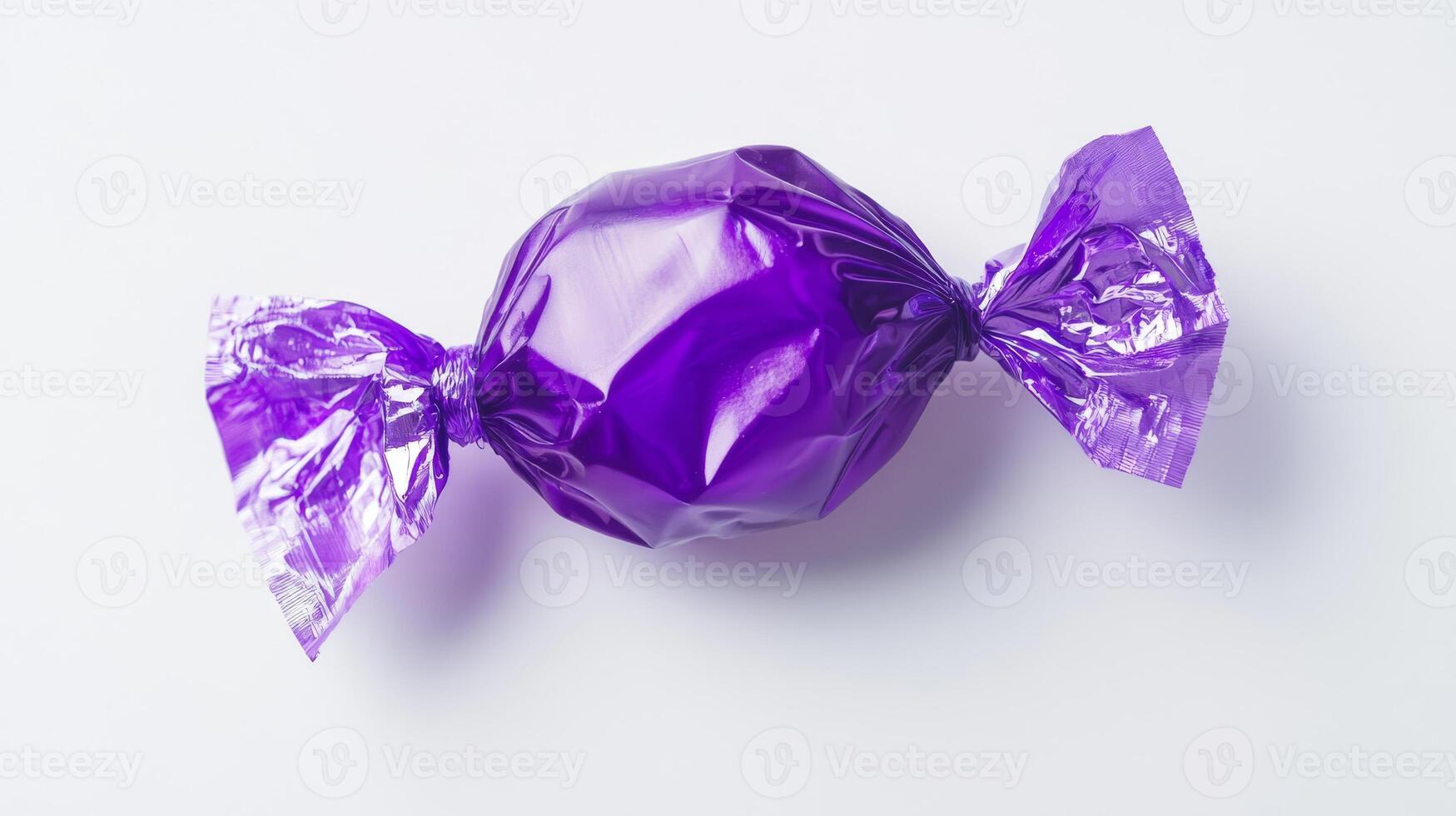 A shiny purple candy wrapped in transparent foil, perfect for sweet indulgence. Ideal for candy lovers and dessert enthusiasts photo