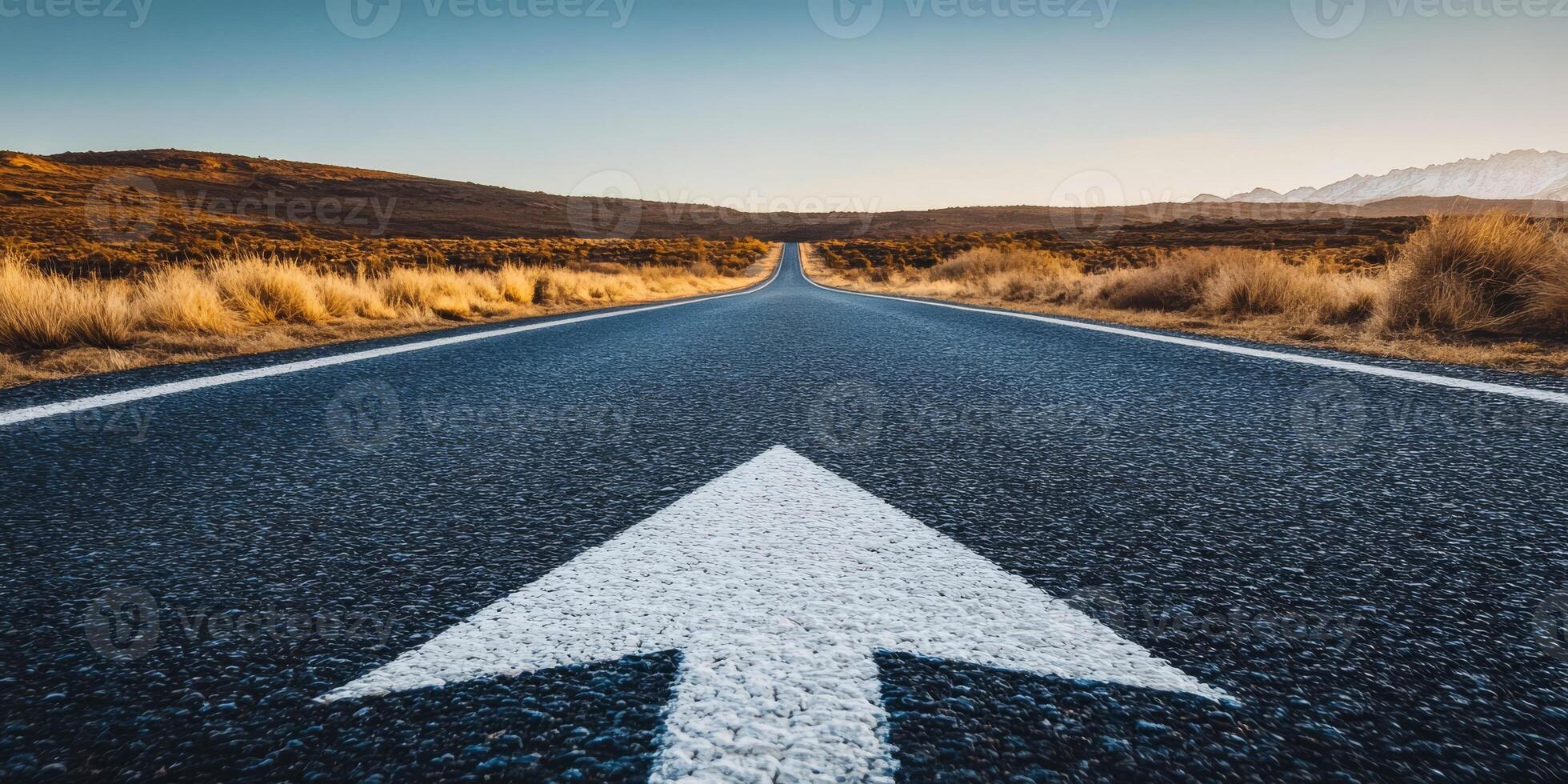 A straight asphalt road ahead, marked by an arrow, symbolizes progress and a promising future filled with opportunities for those brave enough to embrace the unknown and new experiences photo