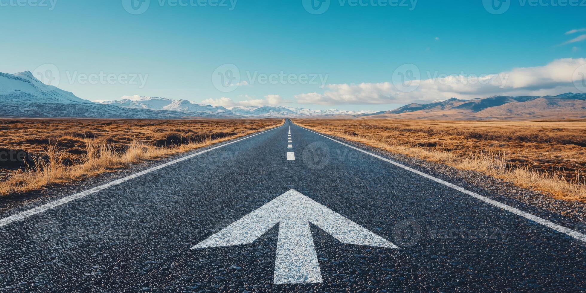 An asphalt road with a forward arrow symbolizes progress and diverse travel experiences, set under a bright blue sky with a few clouds, representing a clear path to future achievements photo