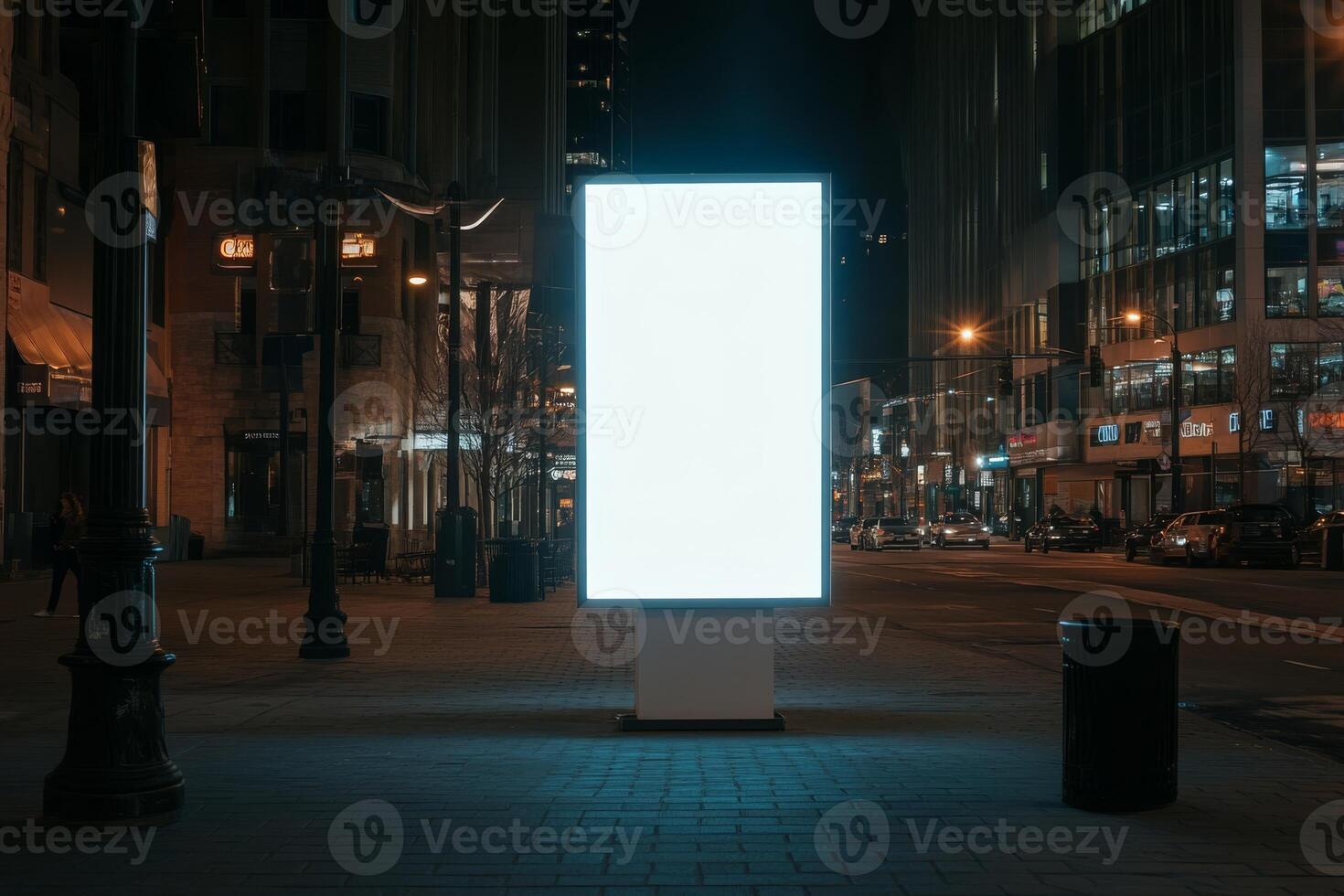 A large, blank LED billboard stands prominently in a bustling city at night, surrounded by beautifully illuminated buildings, creating a serene urban atmosphere amidst the lively city environment photo