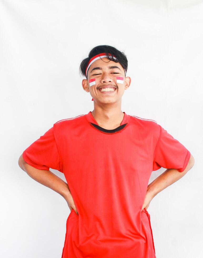 Portrait of asian man isolated on white background. Male model laughing happily in celebration studio photo shoot for Indonesian independence day.