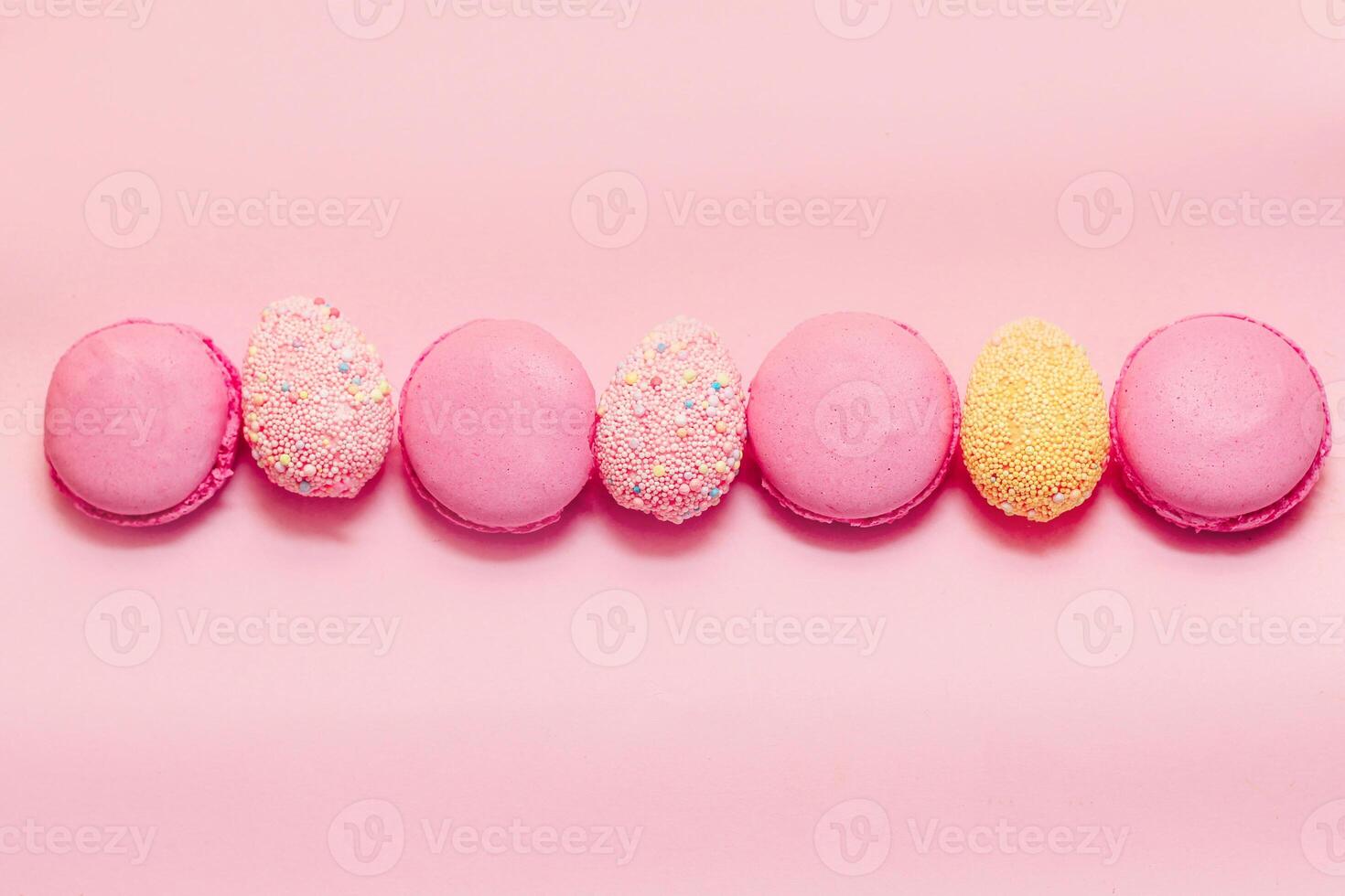 French pink macaroon cookies with Easter decorative eggs. photo