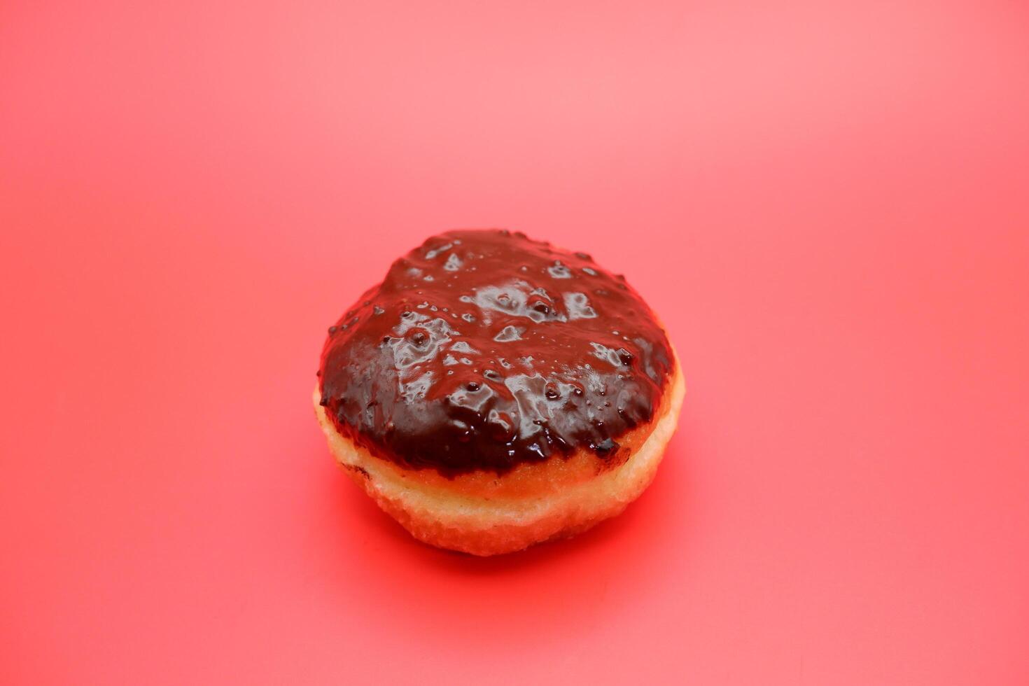 donut cake with chocolate topping on top. donut cake isolated on red background. photo