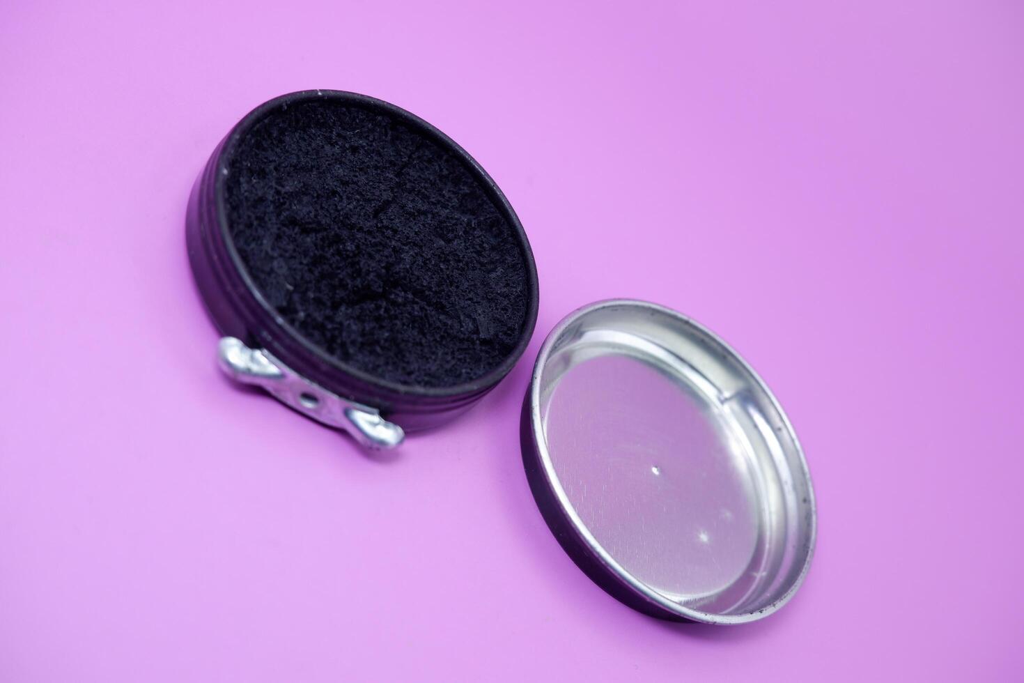 black shoe polish isolated purple background. shoe polish that is usually used with a brush to polish shoes photo