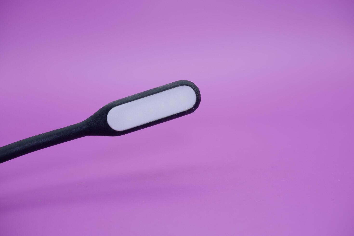 black usb lamp isolated purple background. versatile USB lamp that can be turned on by connecting to a USB port. photo