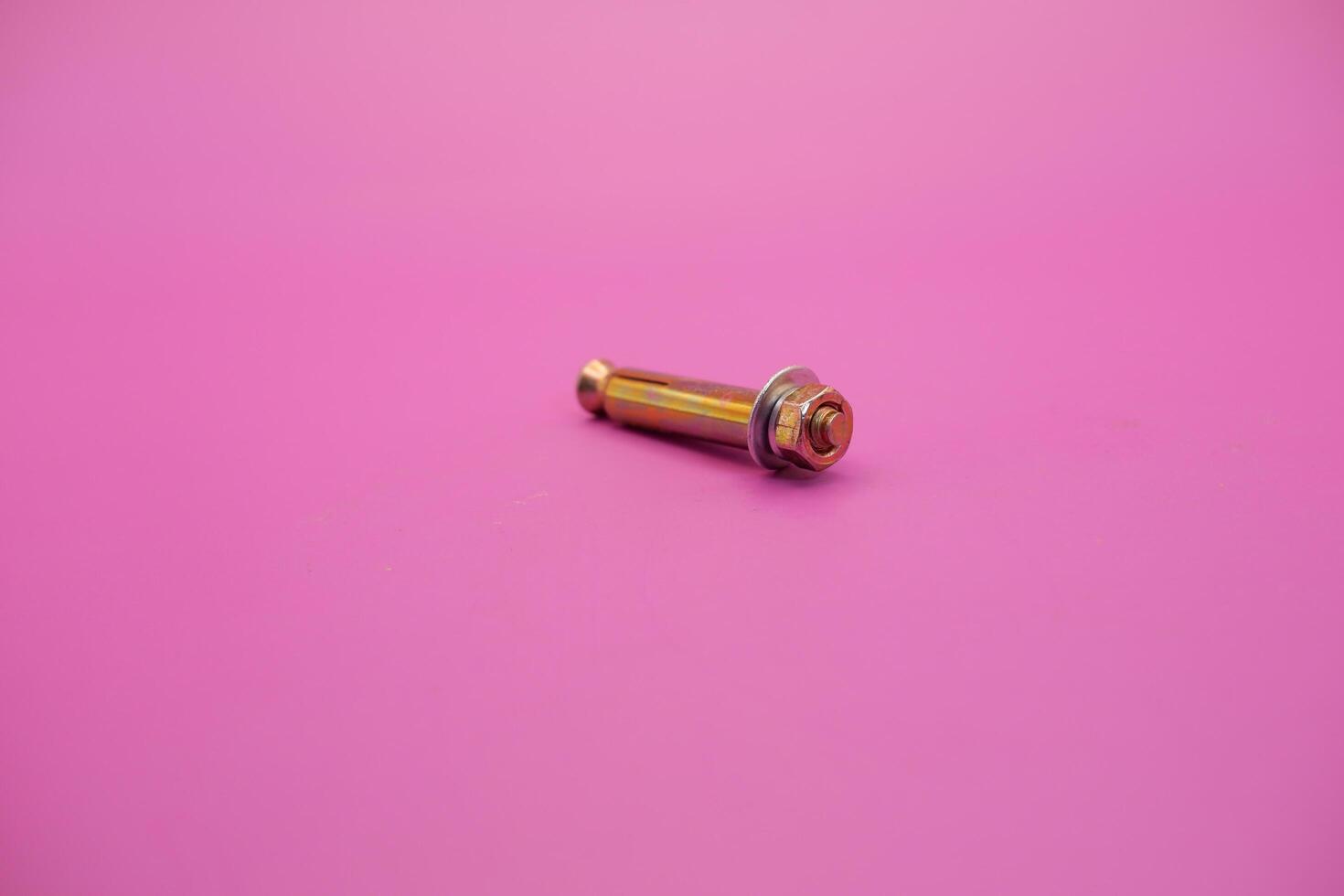 dynabolt isolated on purple background. bolt consisting of washer, sleeve, nut, and threaded bolt. bolt commonly used to fasten objects to concrete. photo