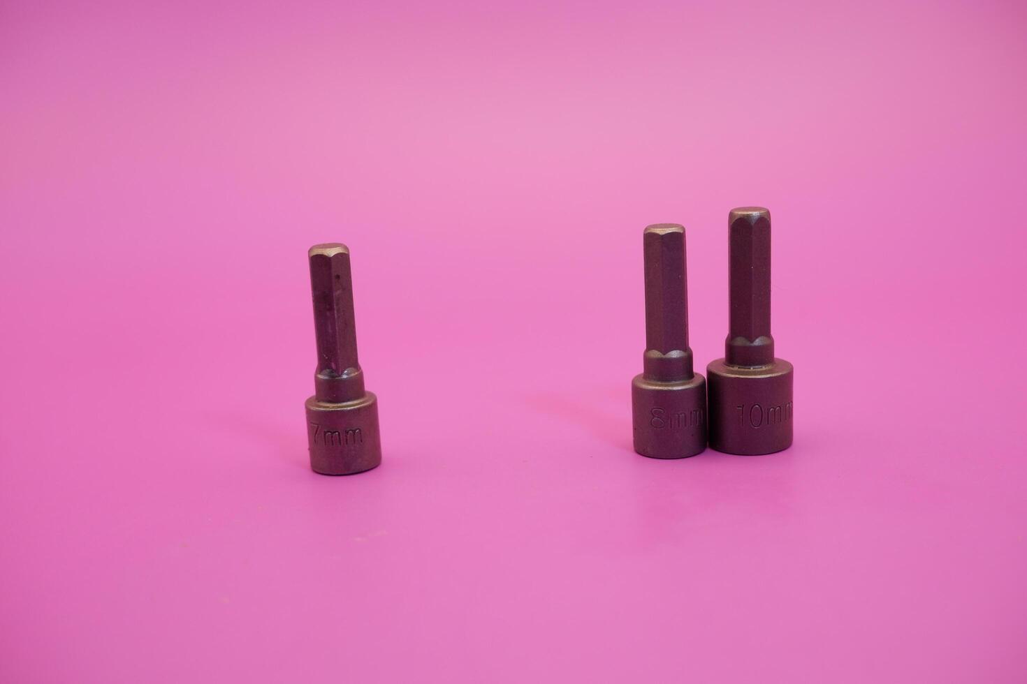 Hexagon screwdriver bit sockets measuring 7 mm, 8 mm, and 10 mm isolated on purple background. photo