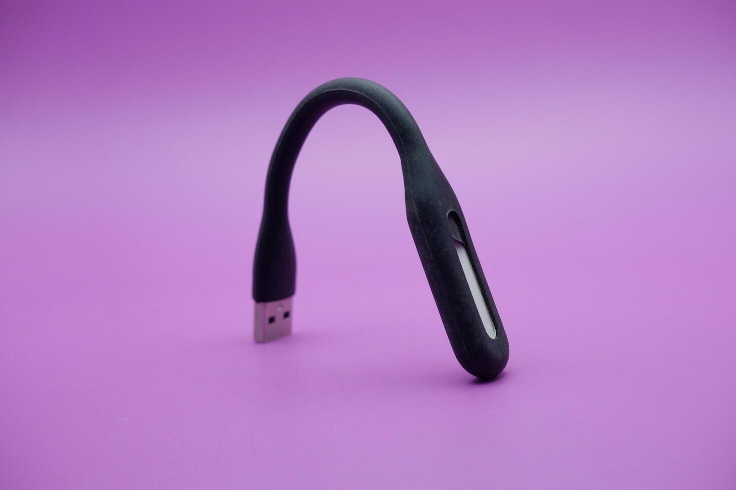 black usb lamp isolated purple background. versatile USB lamp that can be turned on by connecting to a USB port. photo