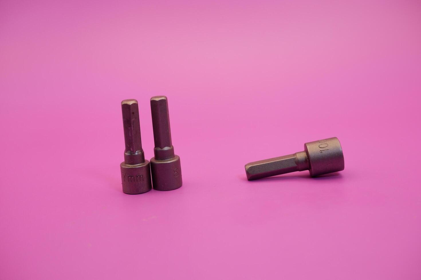 Hexagon screwdriver bit sockets measuring 7 mm, 8 mm, and 10 mm isolated on purple background. photo