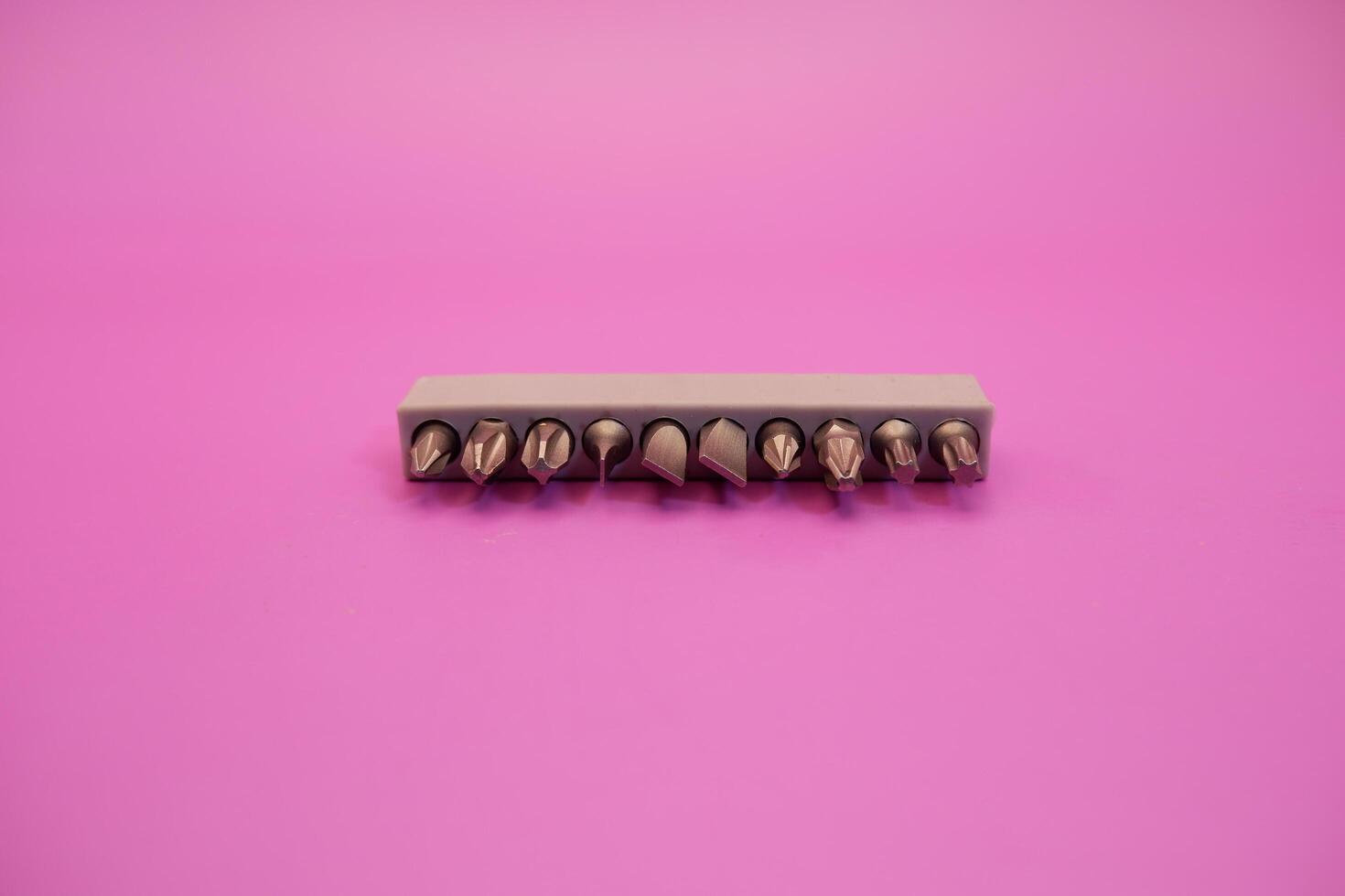a set of screwdriver bits isolated on purple background photo