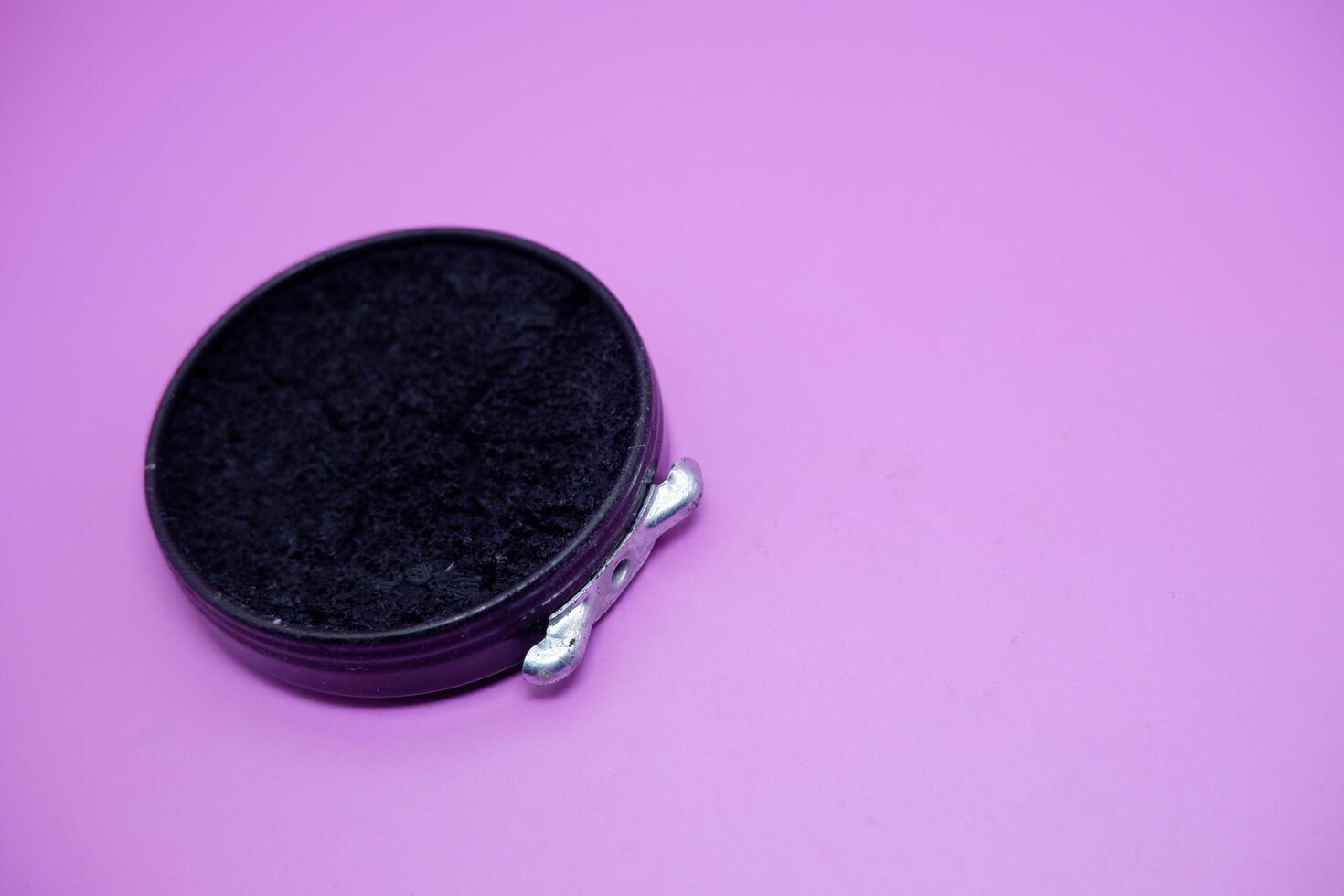 black shoe polish isolated purple background. shoe polish that is usually used with a brush to polish shoes photo
