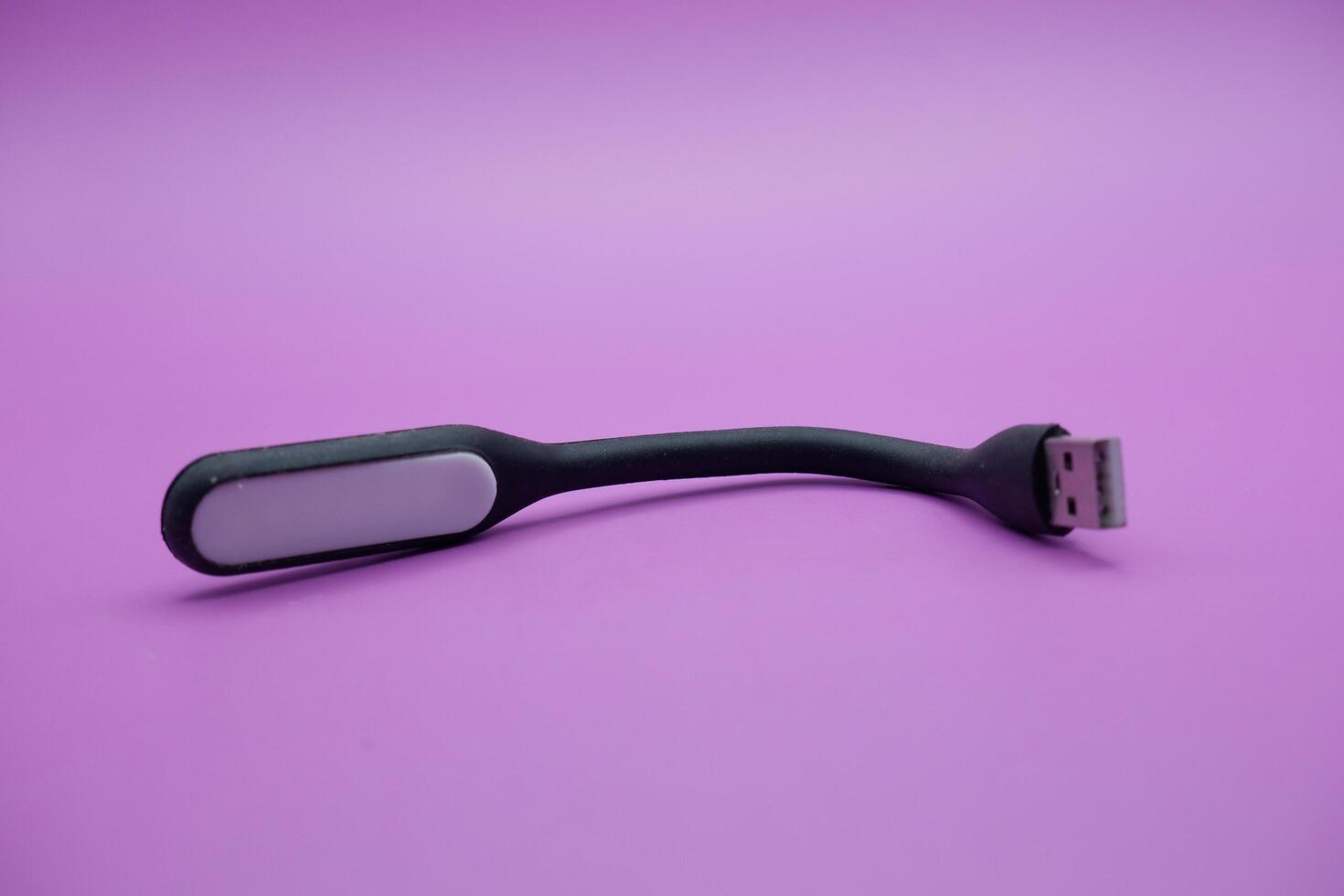 black usb lamp isolated purple background. versatile USB lamp that can be turned on by connecting to a USB port. photo