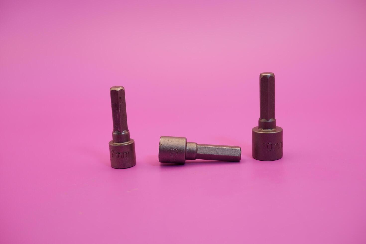 Hexagon screwdriver bit sockets measuring 7 mm, 8 mm, and 10 mm isolated on purple background. photo