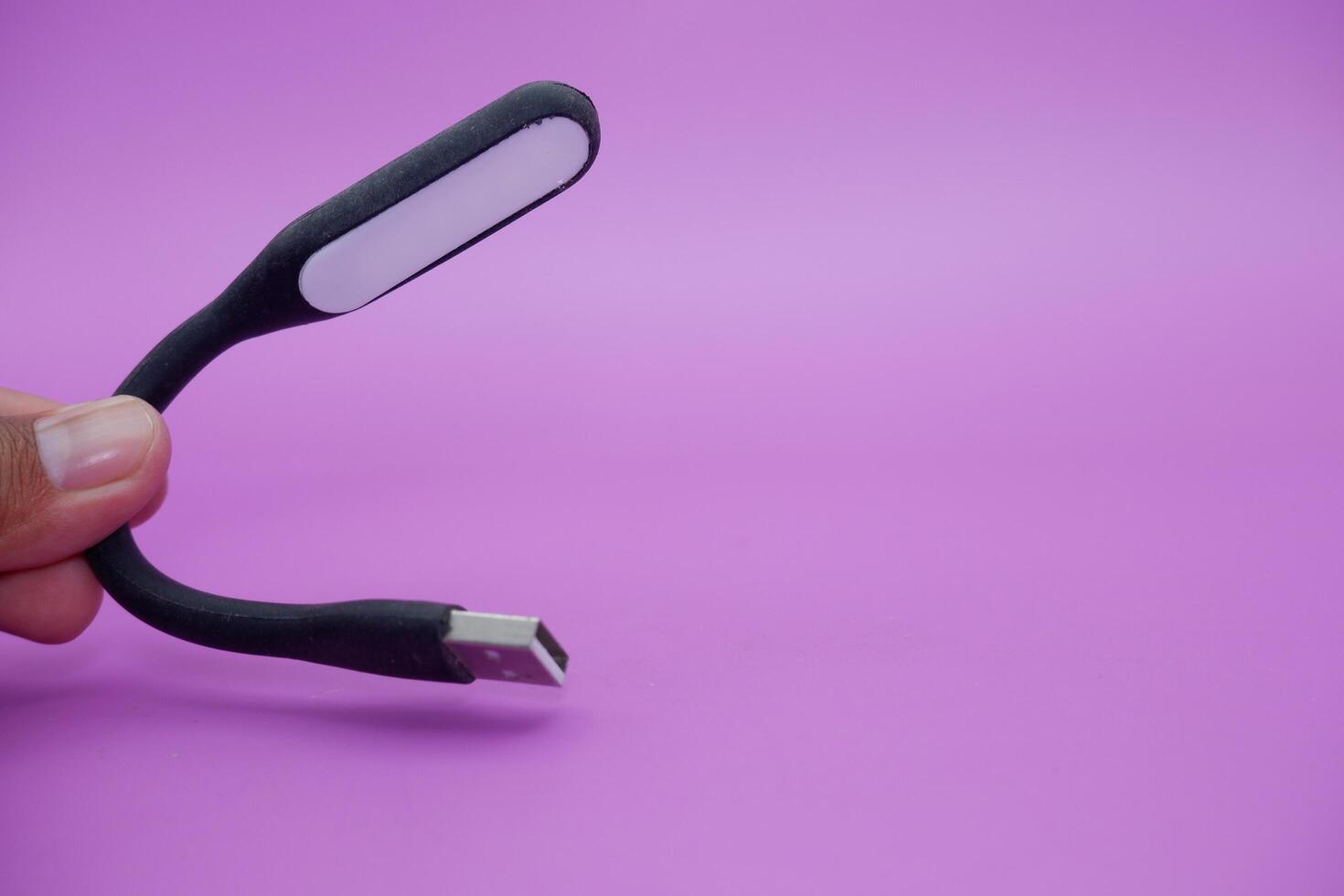 black usb lamp isolated purple background. versatile USB lamp that can be turned on by connecting to a USB port. photo