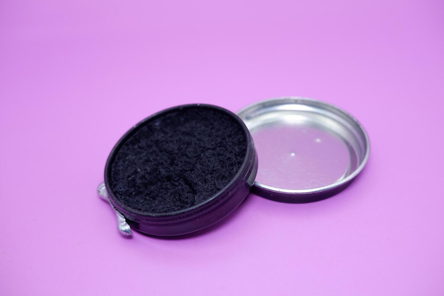black shoe polish isolated purple background. shoe polish that is usually used with a brush to polish shoes photo