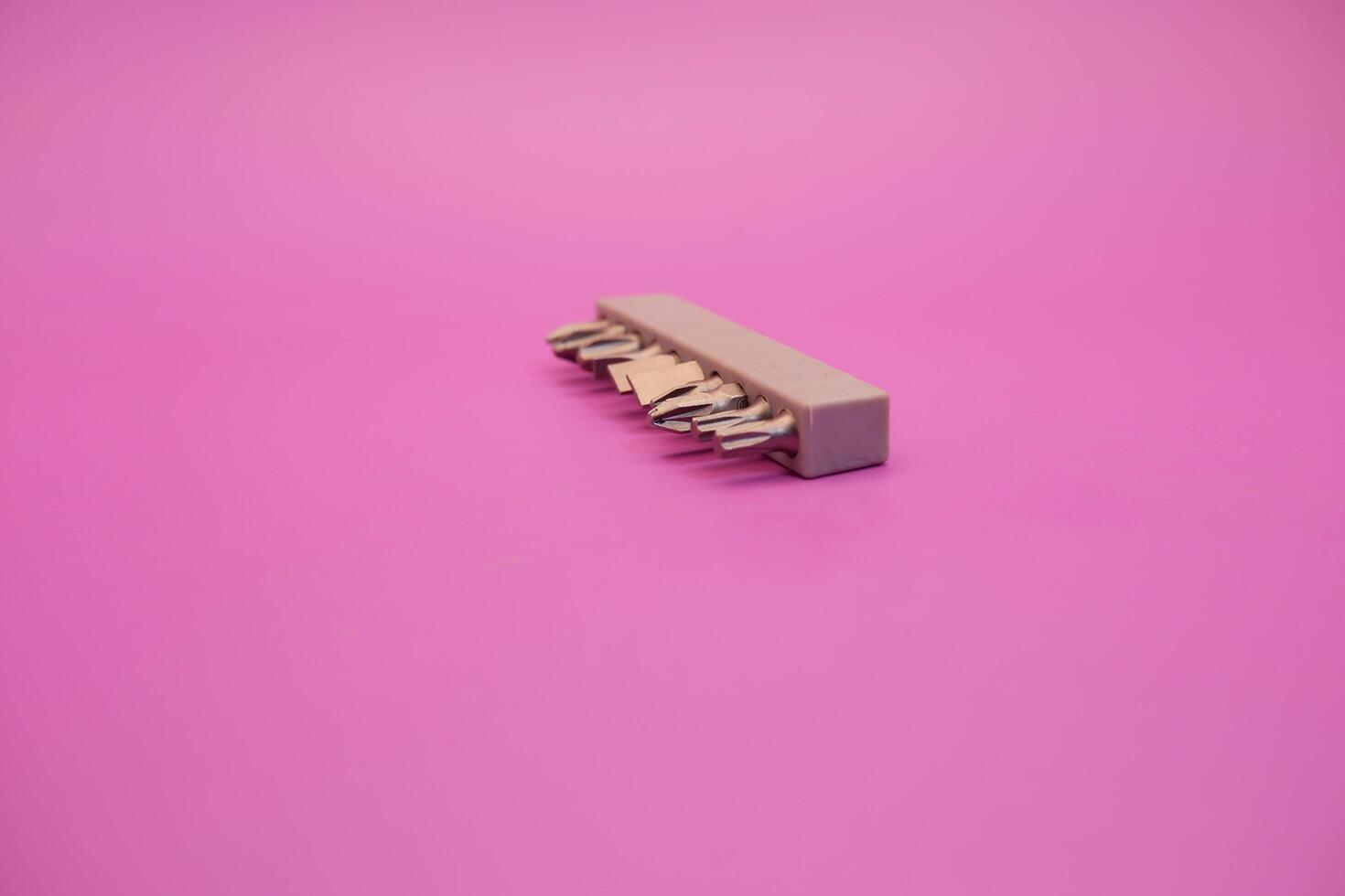 a set of screwdriver bits isolated on purple background photo