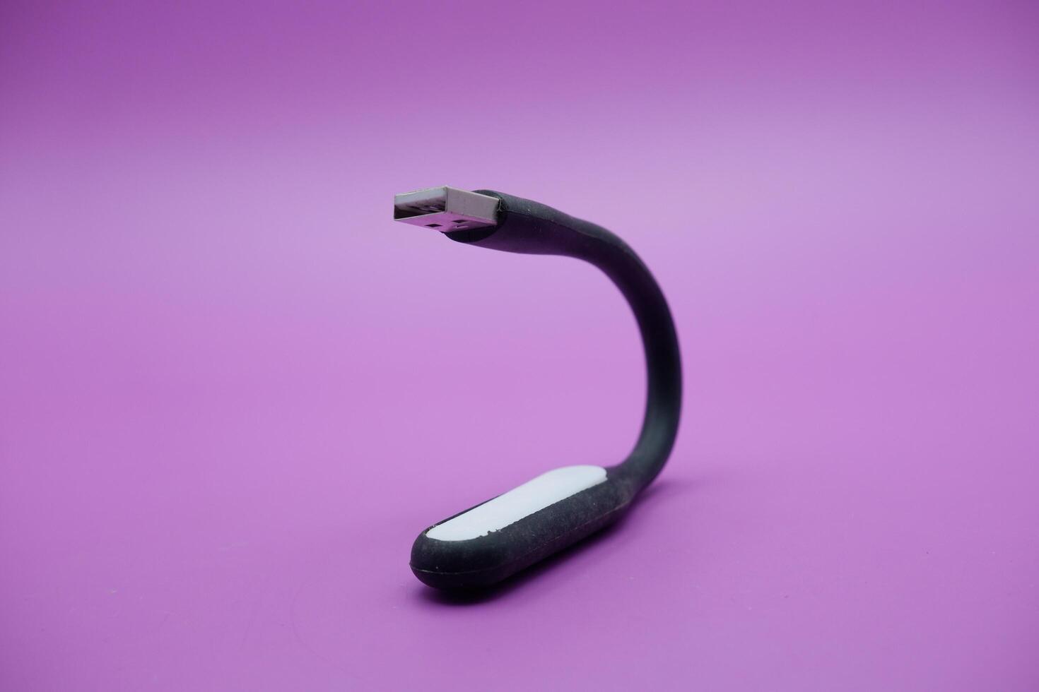 black usb lamp isolated purple background. versatile USB lamp that can be turned on by connecting to a USB port. photo