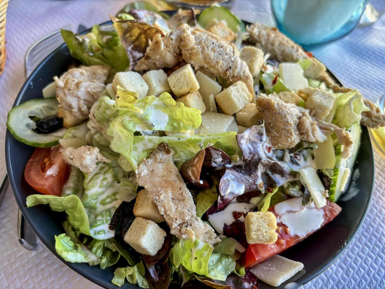 Delicious healthy cesar salad with green and red salad, slices of chicken breast, parmesan and croutons photo
