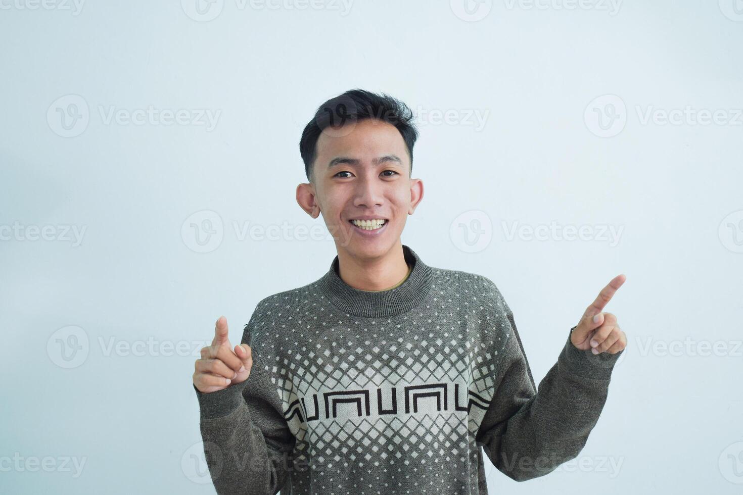 Asian young man showing pointing gesture with gesture and expression. Isolated on white background photo