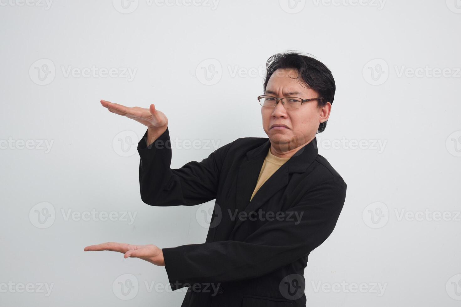 Unhappy and doubtful asian businessman doing smaller thing with 2 hands. Isolated white background photo