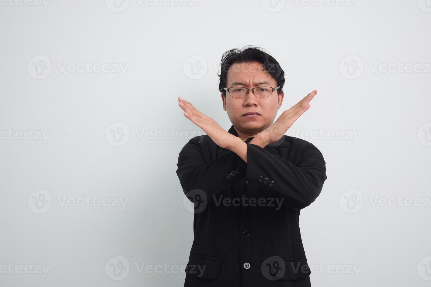 Asian Businessman with casual suit and shirt in studio showing cross hand as no or rejection, deny, prohibition with isolated white background photo