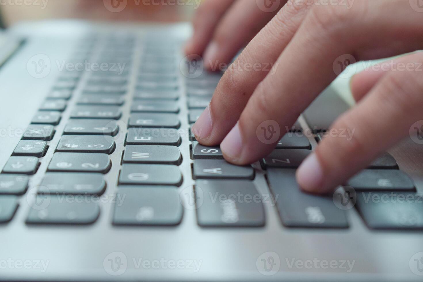 Close up side view young man typing with laptop on table in livingroom, remote working. Digital nomand photo