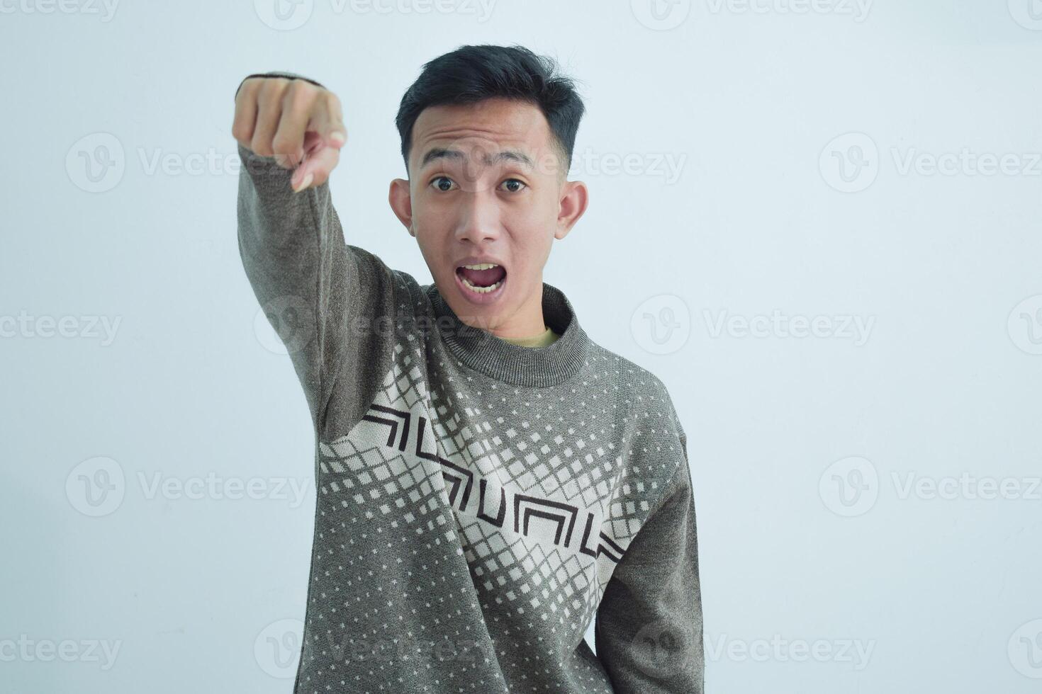 Asian young man showing pointing gesture with gesture and expression. Isolated on white background photo