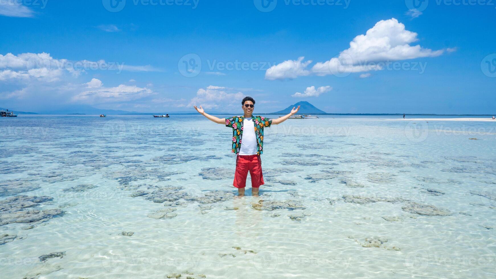 Tropical Island Paradise Nain Mando. Man Standing in Clear Shallow Water photo