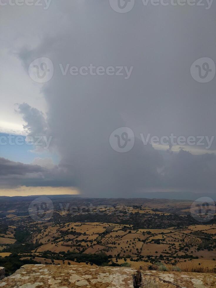 Dark skies loom over the sunlit landscape, a dramatic climate change. photo