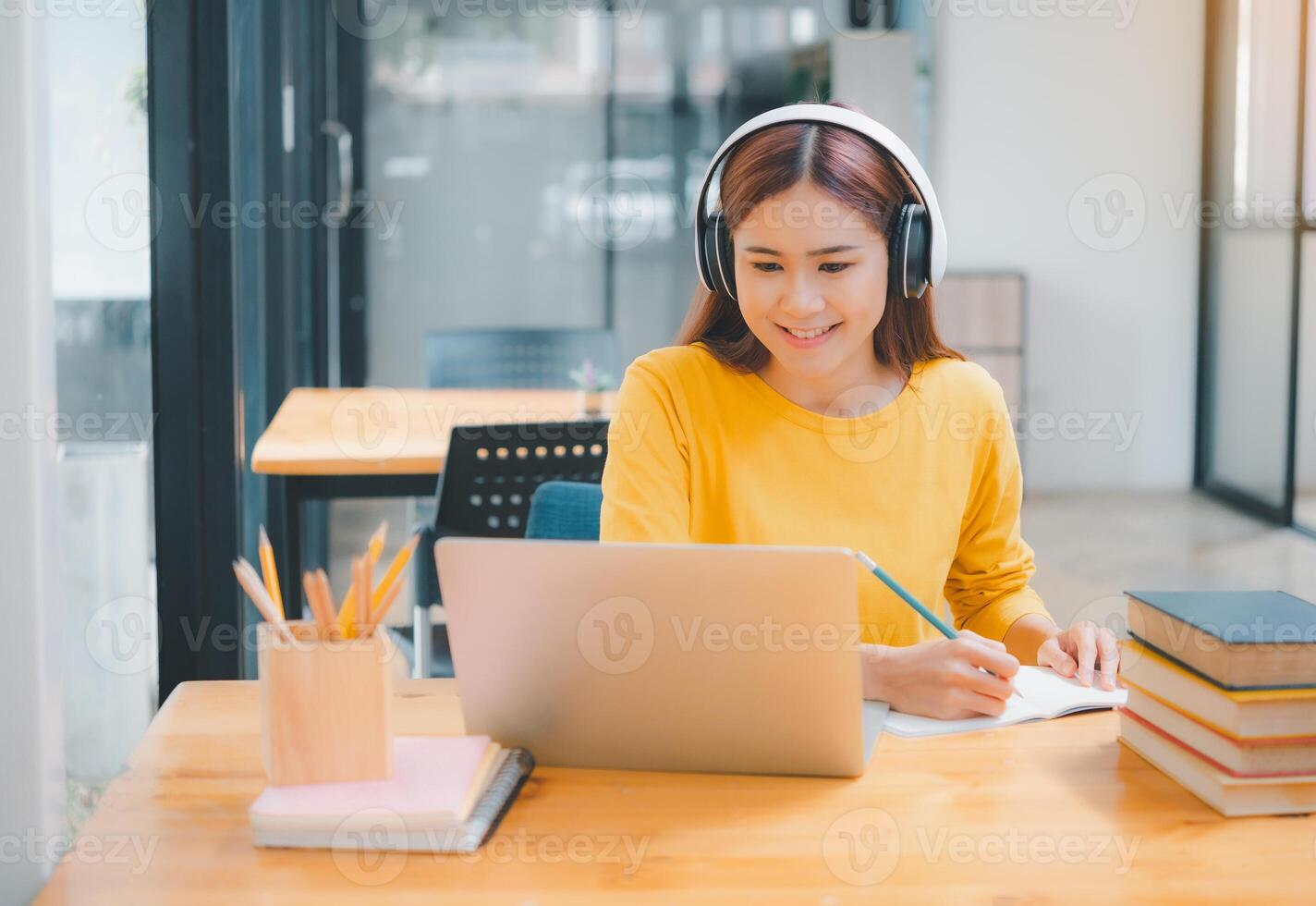 young student wearing headphones studies online, distance learning, and keeps up to date on the global coronavirus pandemic. photo