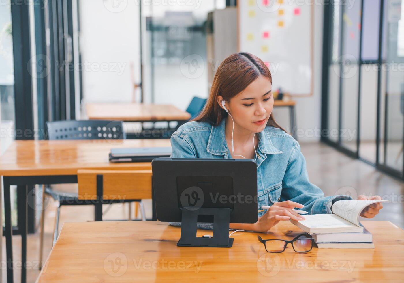 young student wearing small talk studies online, distance learning, and keeps up to date on the global coronavirus pandemic photo