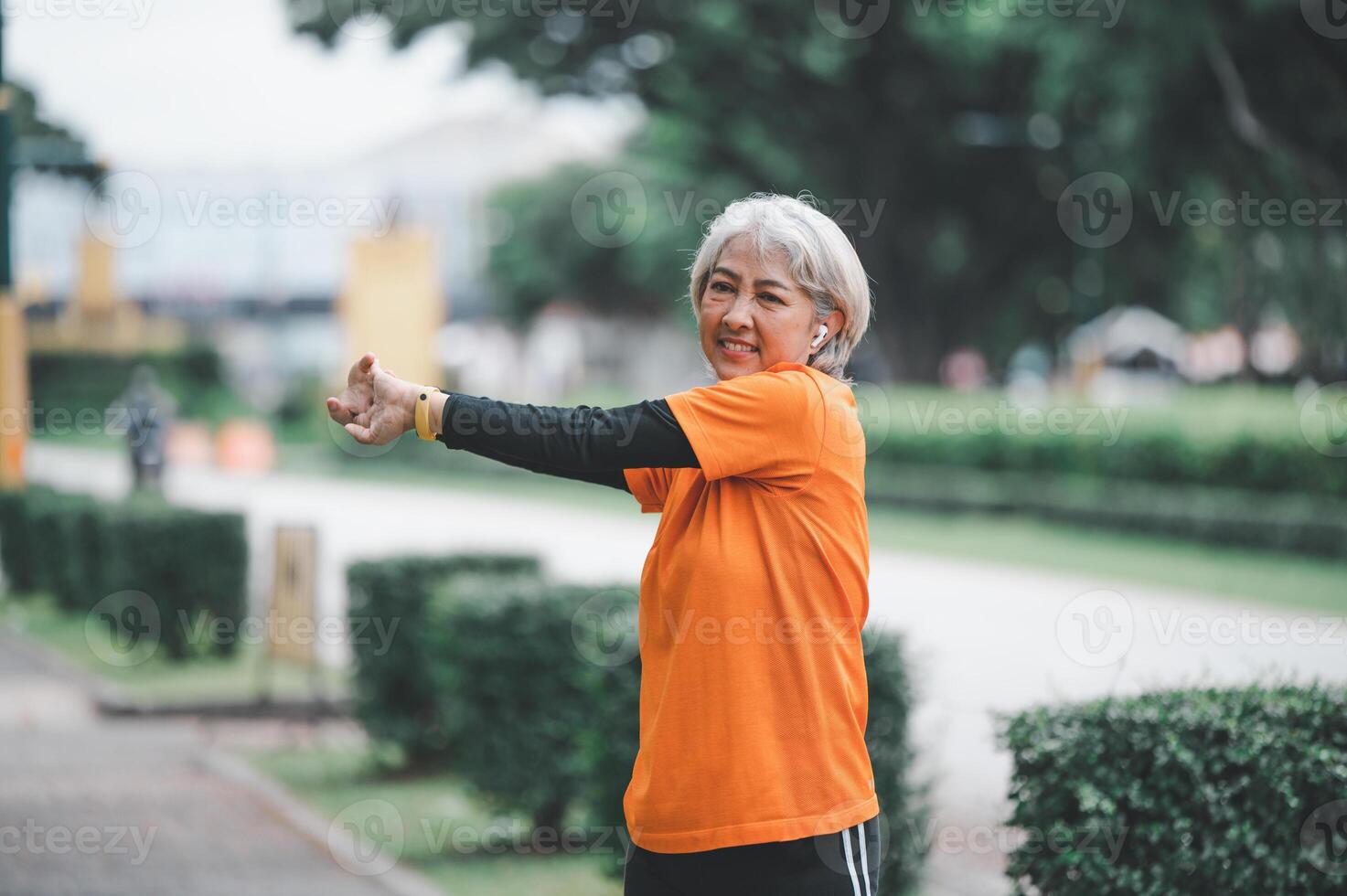 white-haired elderly person exercising in the park early in the morning. photo