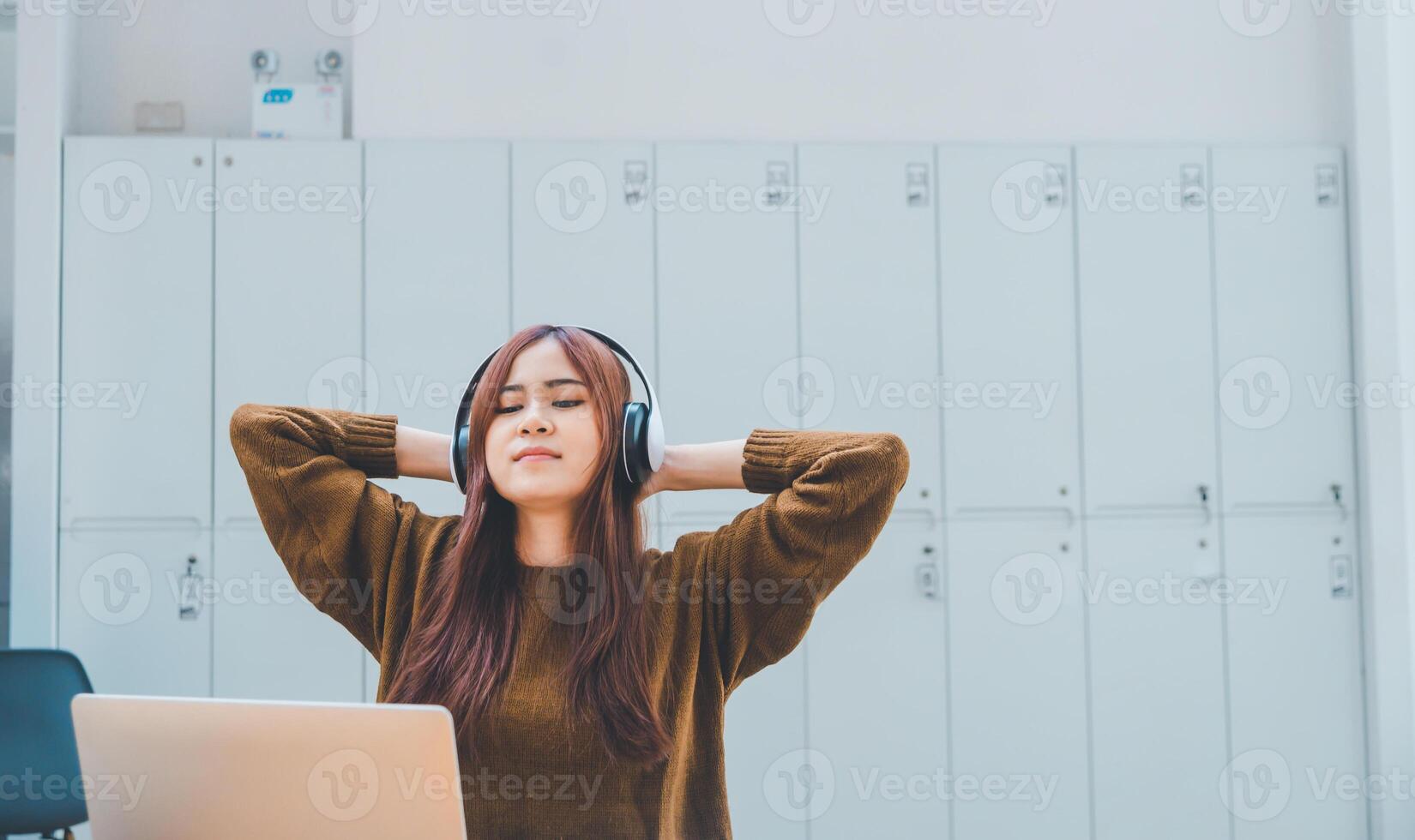 young student wearing headphones is relaxing during long online classes, distance learning, and keeps up to date on the global coronavirus pandemic. photo