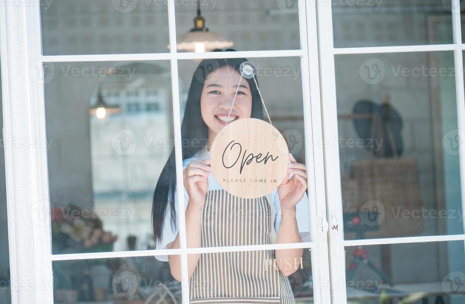Smiling online small business owner holding a sign saying Open and happily working at a courier business offering orders and products to customers.Online retailer - online shopping. photo