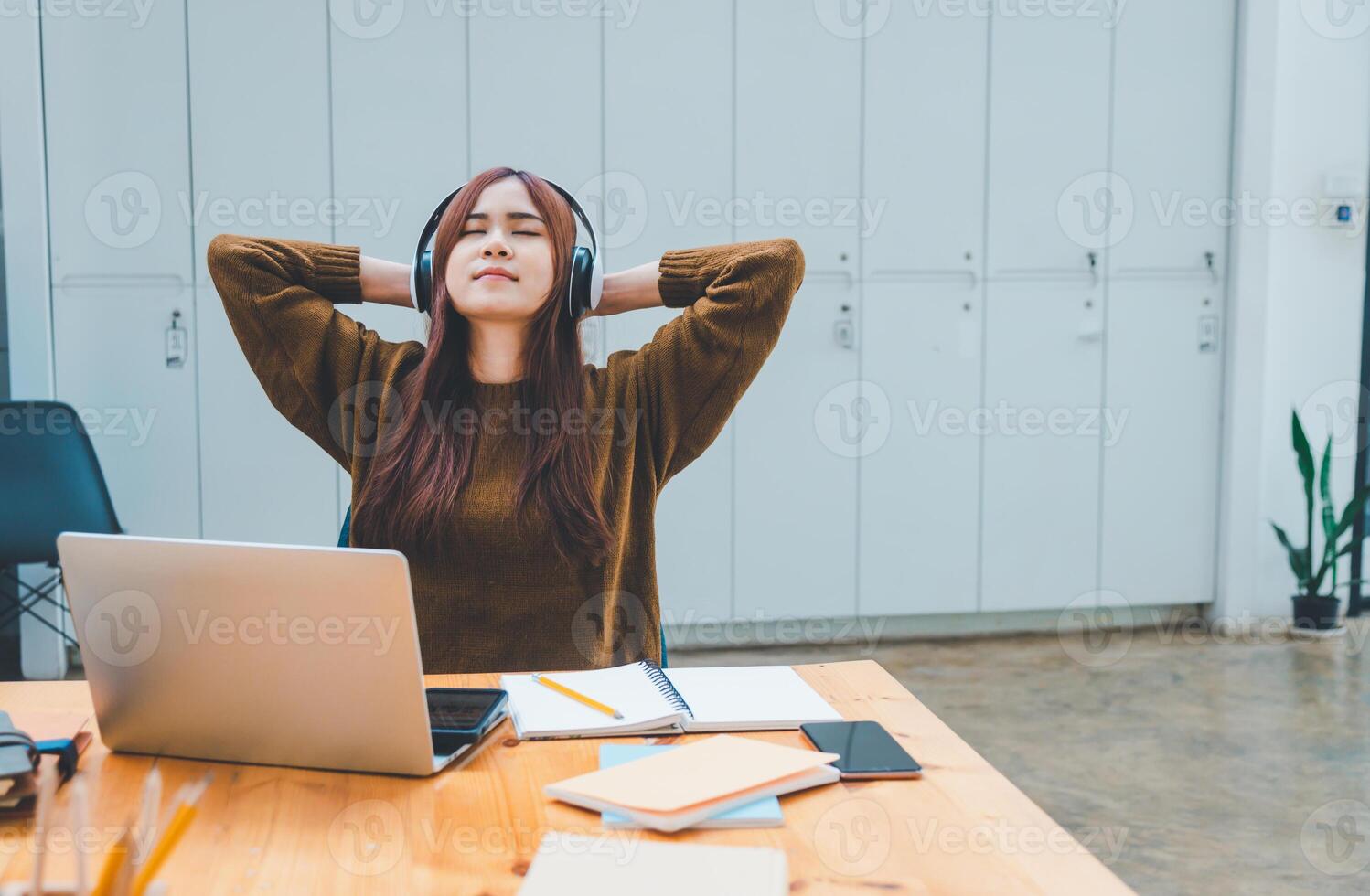 young student wearing headphones is relaxing during long online classes, distance learning, and keeps up to date on the global coronavirus pandemic. photo