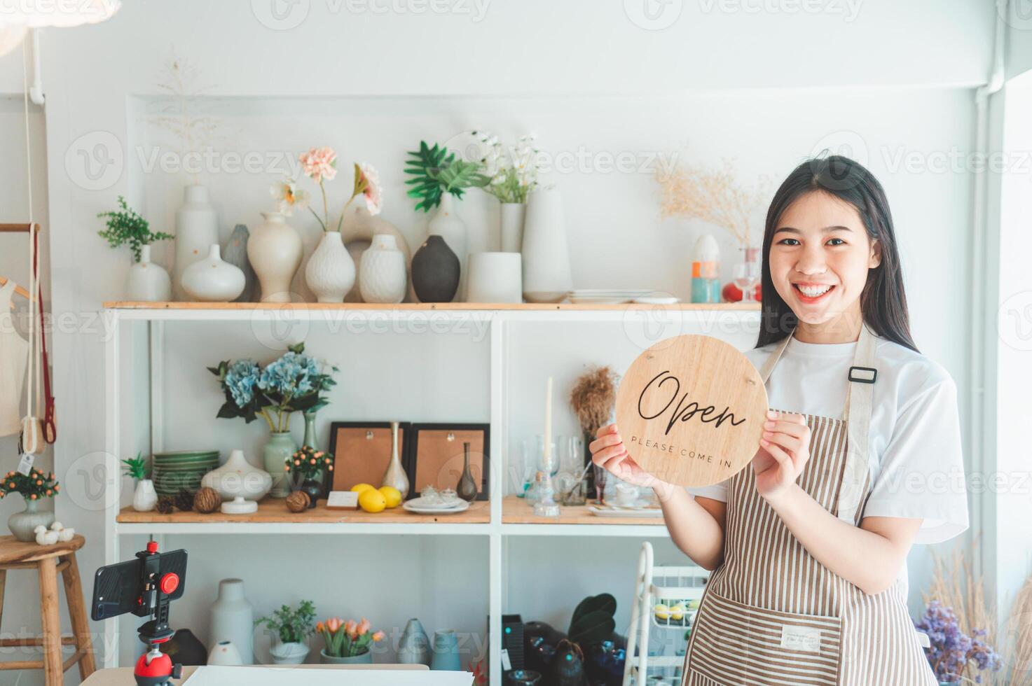 Smiling online small business owner holding a sign saying Open and happily working at a courier business offering orders and products to customers.Online retailer - online shopping. photo