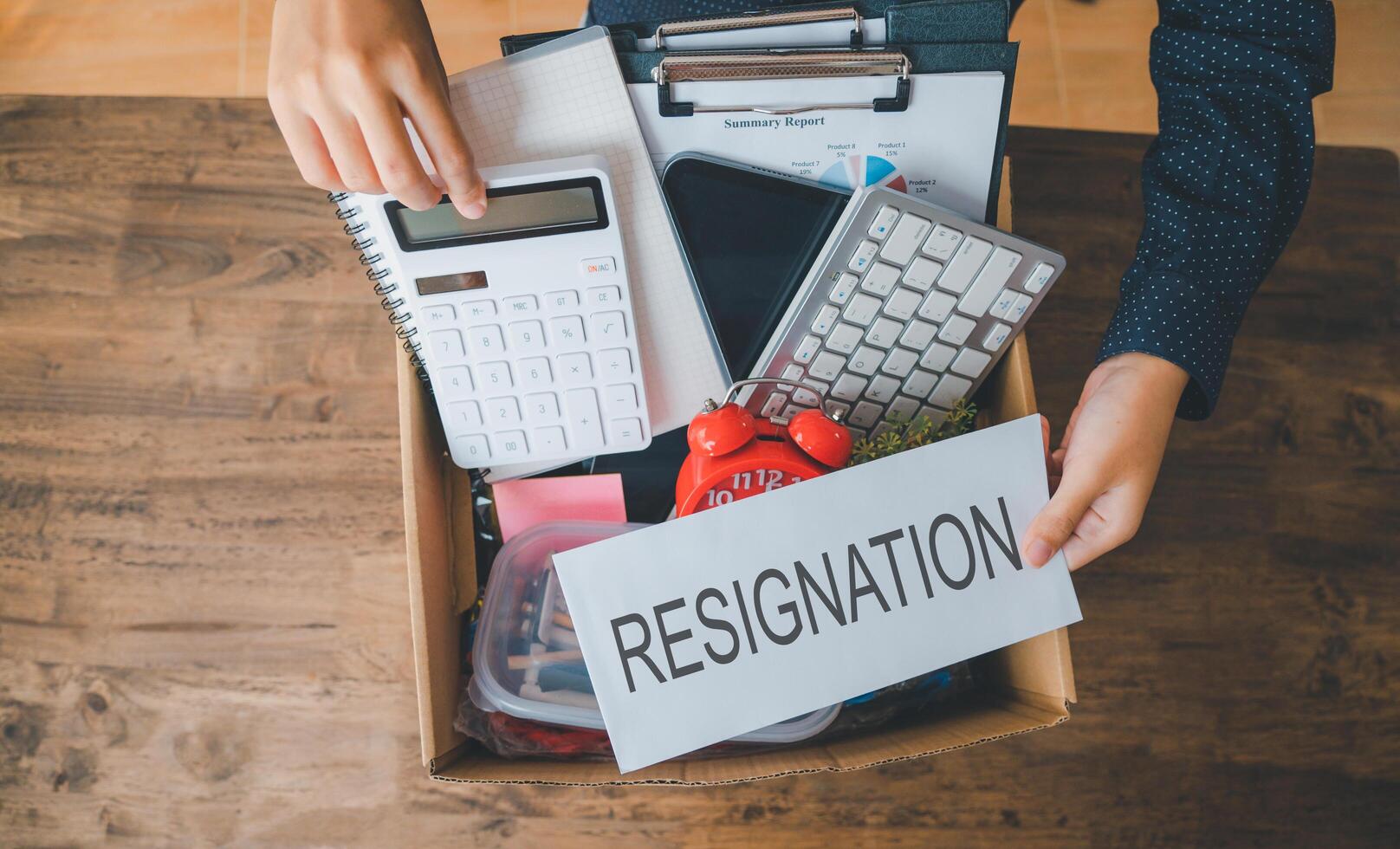 Female company employee packing office supplies and personal items in cardboard boxes before leaving the office to look for a new job, being fired, or being dismissed by the employer. photo