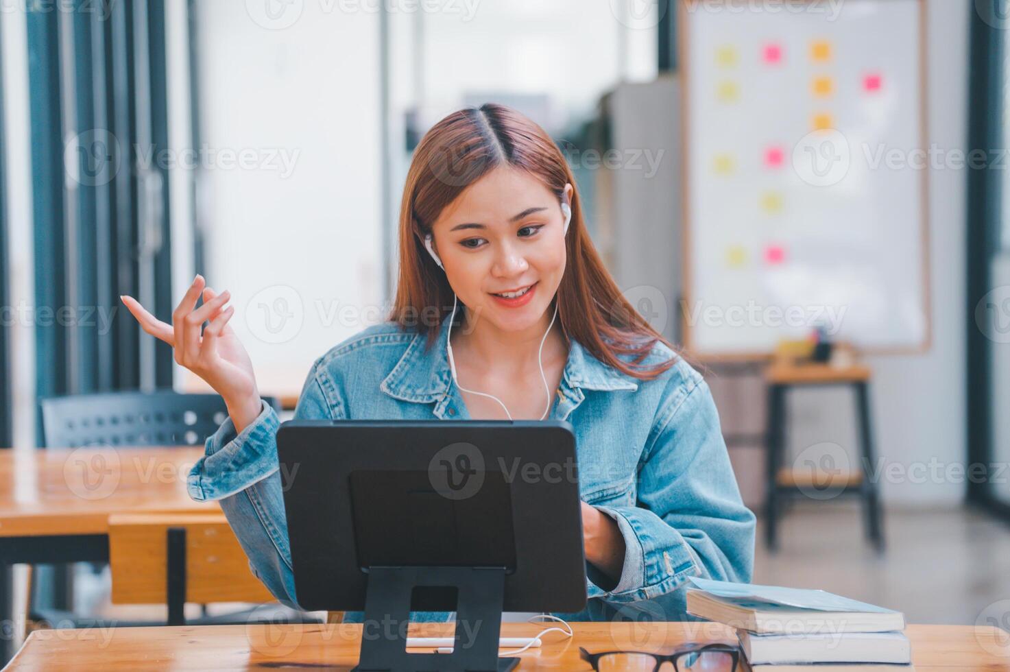 young student wearing small talk studies online, distance learning, and keeps up to date on the global coronavirus pandemic photo