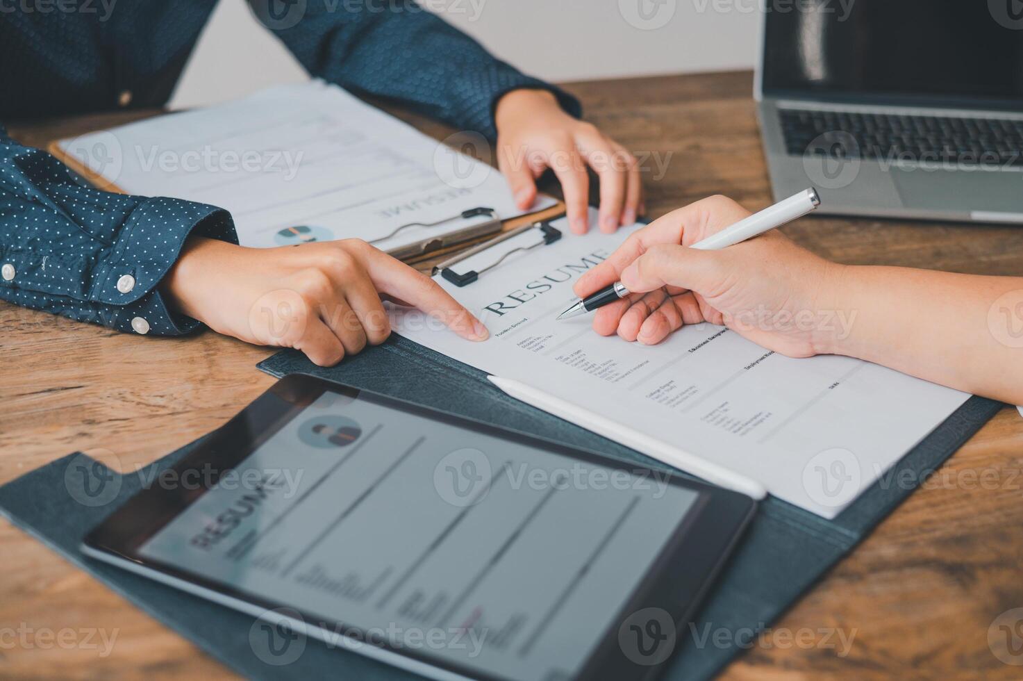 HR managers are interviewing job applicants who fill out their resume on the job application form in order to consider accepting a job as a company photo
