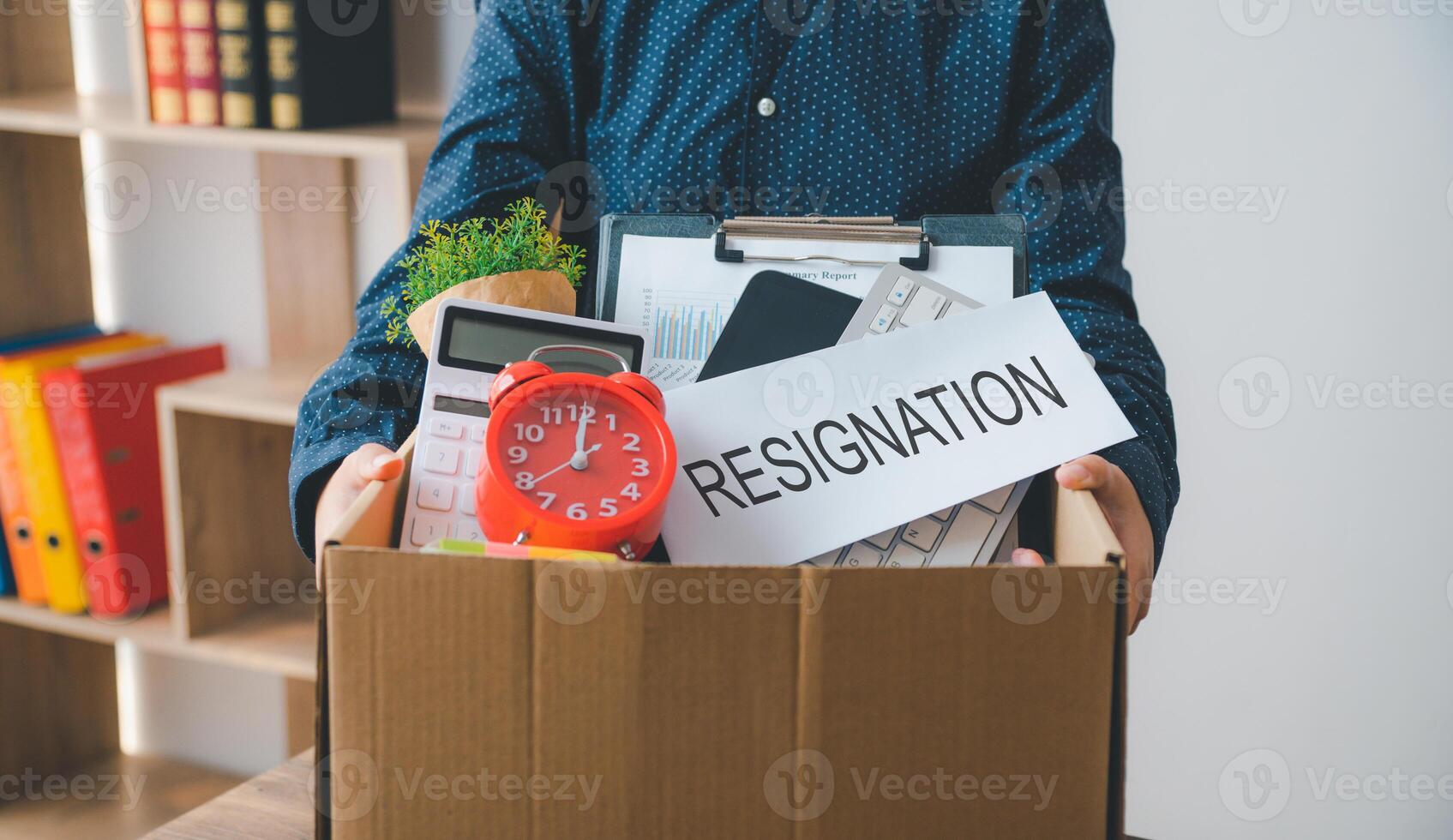 Female firm employee leaving the office with cardboard boxes containing office supplies and personal items after quitting to find a new job, being fired, or being fired from the company. photo