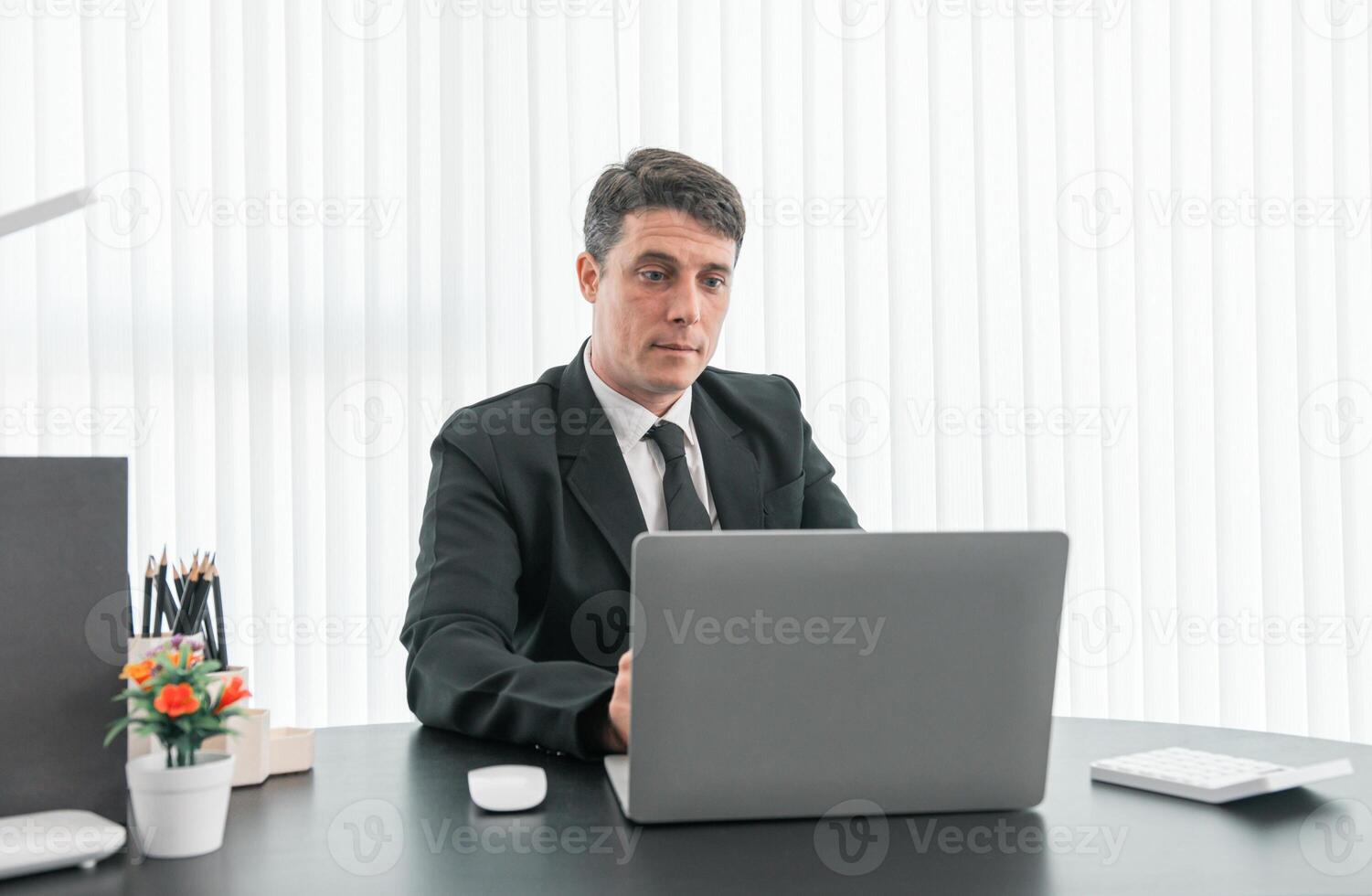 businessman sitting at worktable at modern office analyzing company performance, finance and investment photo