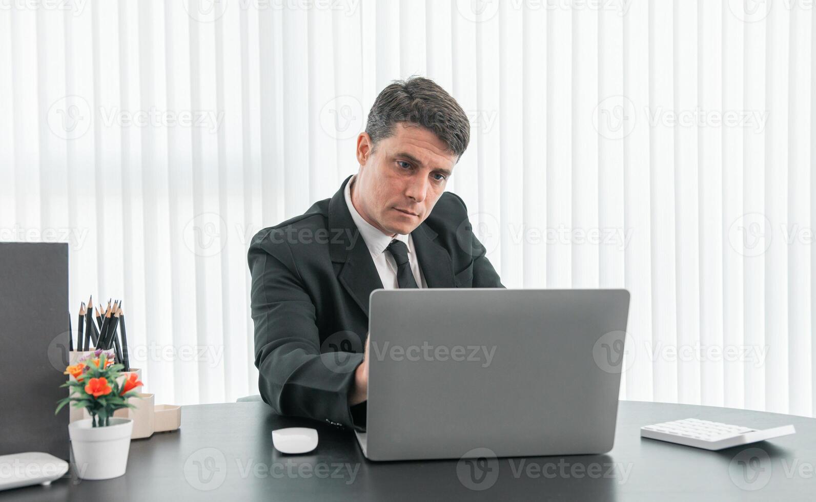 businessman sitting at worktable at modern office analyzing company performance, finance and investment photo