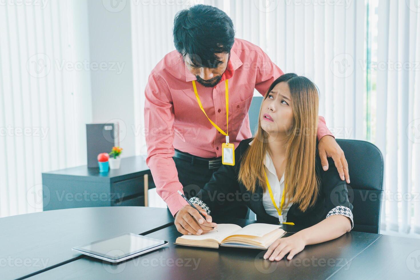Boss or supervisor touching female employee's shoulder Causing young employees to resist because they are uncomfortable and afraid of being sexually abused photo