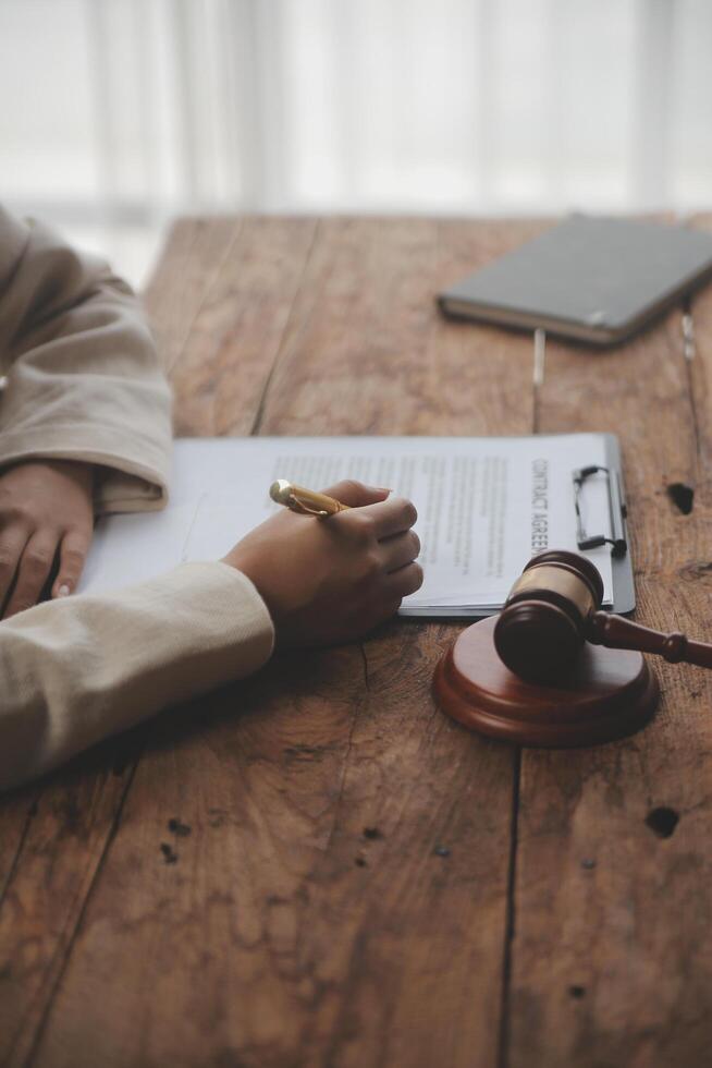 Business and lawyers discussing contract papers with brass scale on desk in office. Law, legal services, advice, justice and law concept picture with film grain effect photo