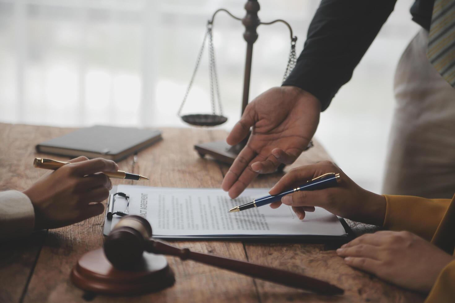 Business and lawyers discussing contract papers with brass scale on desk in office. Law, legal services, advice, justice and law concept picture with film grain effect photo