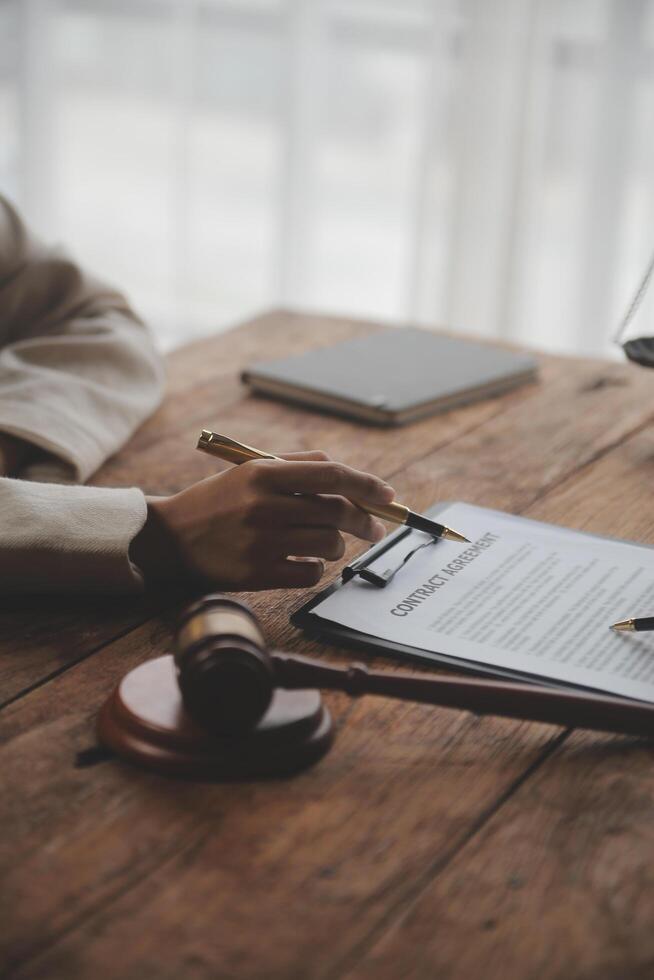 Business and lawyers discussing contract papers with brass scale on desk in office. Law, legal services, advice, justice and law concept picture with film grain effect photo