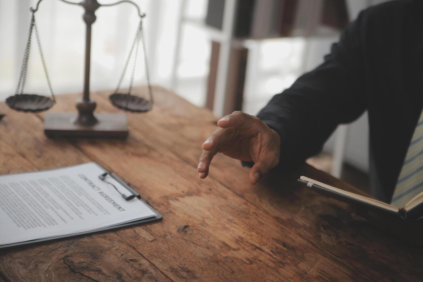 Business and lawyers discussing contract papers with brass scale on desk in office. Law, legal services, advice, justice and law concept picture with film grain effect photo