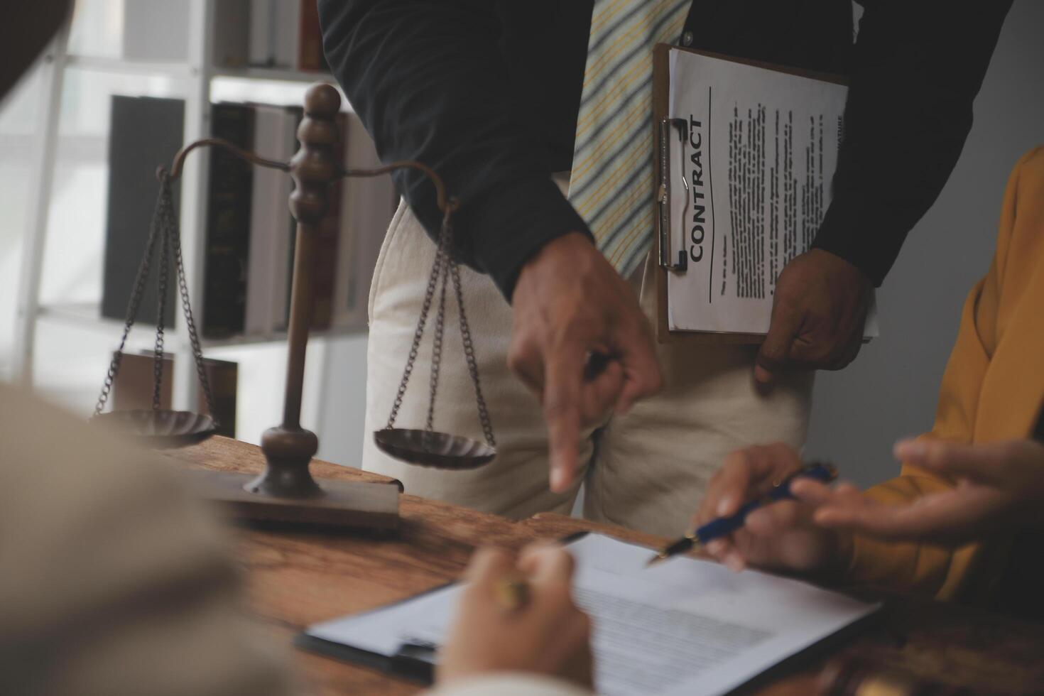Business and lawyers discussing contract papers with brass scale on desk in office. Law, legal services, advice, justice and law concept picture with film grain effect photo